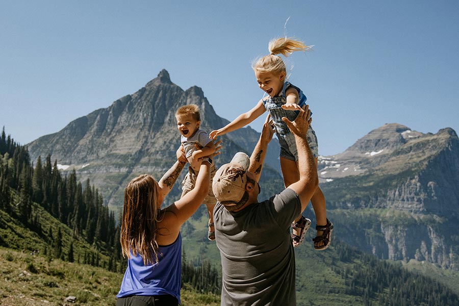Two parents playing with their kids in Glacier National Park